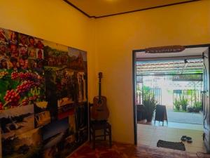 巴色DD Guest House的一间设有吉他和墙上一幅画的房间