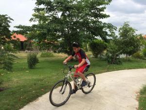 巴吞他尼Sripiamsuk Resort Bangkok的骑着自行车的男孩