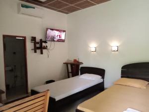 恩比利皮蒂耶The Cascade Lodge的客房设有两张床和一台墙上的电视。