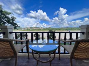 清孔Chiangkhong Teak Garden Riverfront Onsen Hotel- SHA Extra Plus的水景阳台的玻璃桌