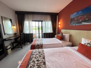 清孔Chiangkhong Teak Garden Riverfront Onsen Hotel- SHA Extra Plus的酒店客房配有两张床和一张书桌