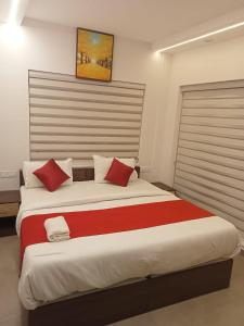 卡兰古特La Gabriell beach inn的一间卧室配有一张带红色枕头的大床