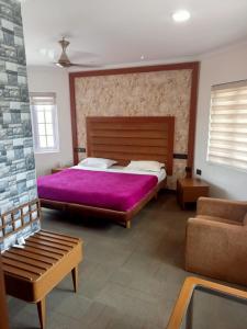 卡兰古特La Gabriell beach inn的一间卧室配有一张大床和紫色毯子