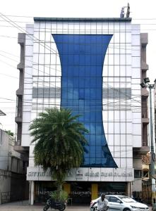 库姆巴科纳姆sitthi residency的一座蓝色的建筑,前面有棕榈树