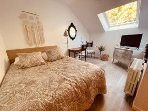瓦讷Les Suites du 119的一间卧室配有一张床、一张书桌和一台电视