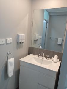 卧龙岗Solomon Inn Motel Figtree的浴室设有白色水槽和镜子