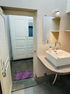 乌代浦Atithya的一间带水槽的浴室和一个带镜子的门