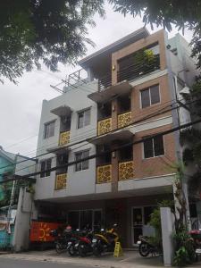 CaintaSunny Day Residences Cainta的停在前面的摩托车建筑