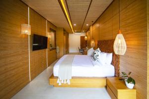 乌布Ubud Riverside Villa的一间卧室配有一张床和一台电视