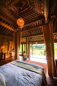 乌布Ubud Riverside Villa的一间卧室设有一张带木制天花板的大床