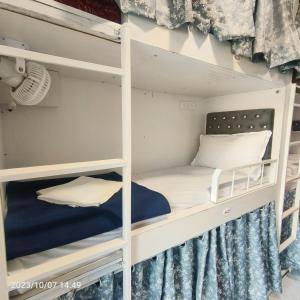 孟买Marol Metro Dormitory的配有白色双层床的客房内的双层床