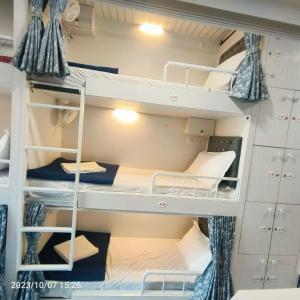 孟买Marol Metro Dormitory的一间小房间,内设双层床