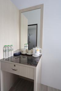 卡塔海滩幻想山简易别墅酒店的浴室柜台配有瓶装水和镜子