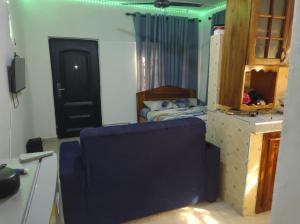 SunyaniKingee Lodge的一间设有一张床铺的房间,配有一张蓝色椅子