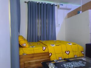 SunyaniKingee Lodge的一间卧室配有黄色的床和黄色的毯子