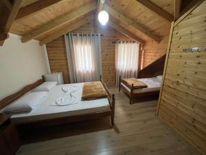 RazëmVila Pepaj Razem的小木屋内一间卧室,配有两张床