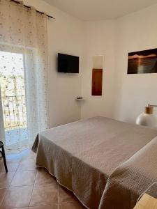 维科德尔加尔加诺Marì的卧室配有一张床,墙上配有电视