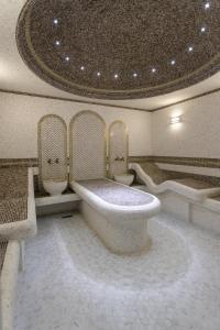 塔什干Rayyan Hotel & SPA Tashkent的带浴缸和两把椅子的大浴室