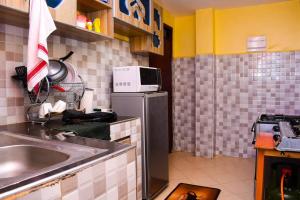 MeruEP Home的厨房配有水槽和微波炉