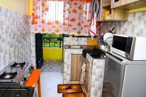 MeruEP Home的一间带炉灶和微波炉的小厨房
