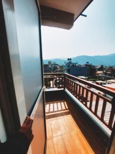 博卡拉Nishan Apartments -Lakeside的能从阳台的窗户望出去的人