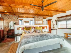 塔尔巴赫Duikersdrift Winelands Country Escape的一间卧室设有一张带木制天花板的大床