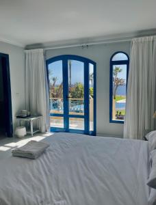 沙姆沙伊赫Ras Katy Sunset Views的一间卧室设有一张大床和两个窗户。