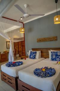 米查维米查维日落湾度假酒店的一间卧室配有两张蓝色和白色的床