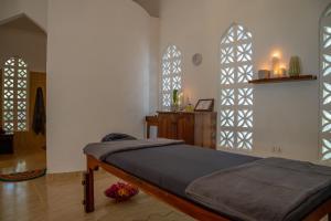 米查维米查维日落湾度假酒店的一间卧室设有一张床和两个拱形窗户