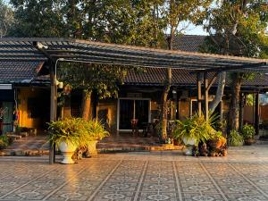 Ban Muang Baบ้านพักสิริ มุกดาหาร (Baan Siri Mukdahan)的楼前有盆栽的亭子
