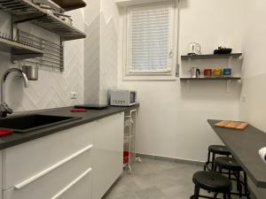 佩罗My Red at Milano Mind的厨房配有水槽和带凳子的台面