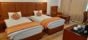 菩提伽耶玛亚遗产酒店的酒店客房配有两张床和一张书桌