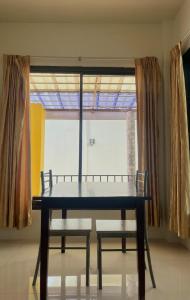 Ban Muang Baบ้านพักสิริ มุกดาหาร (Baan Siri Mukdahan)的窗前的一张桌子和两把椅子