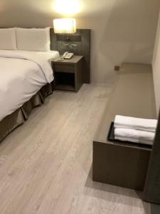 高雄金狮湖大酒店的酒店客房配有一张床、一张书桌和一部电话