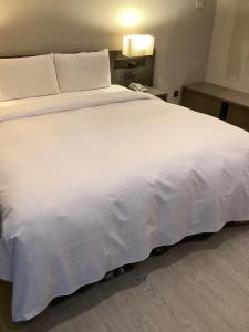 高雄金狮湖大酒店的一张大白色的床,位于酒店客房内
