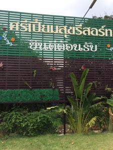 巴吞他尼Sripiamsuk Resort Bangkok的公园的标志,带长凳
