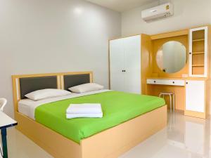 Ban Muang Baบ้านพักสิริ มุกดาหาร (Baan Siri Mukdahan)的一间卧室配有一张带镜子的绿色床