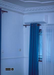 BueaCloudHill的一间设有蓝色窗帘和窗户的客房