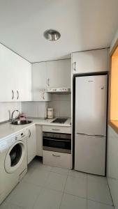 马德里Samaniego suite, AirPort, ifema turístico的白色的厨房配有冰箱和洗碗机。