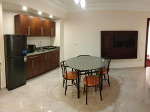 开罗蒙特开罗服务式公寓的厨房配有桌椅和冰箱。