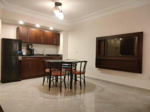 开罗蒙特开罗服务式公寓的厨房配有桌椅和电视。