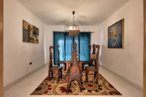 东勒贡10 bedroom Luxurious Villa的一间位于地毯上的带桌椅的用餐室