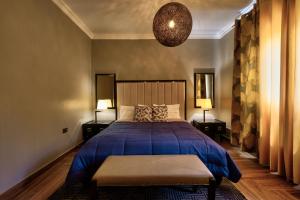 东勒贡10 bedroom Luxurious Villa的一间卧室配有一张蓝色的床和两盏灯。