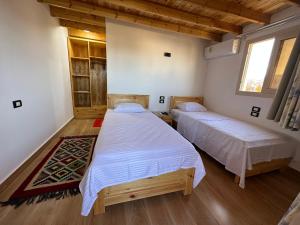 达哈布Beit Tolba的铺有木地板的客房内的两张床