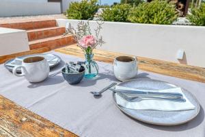 卡武埃鲁Quinta do Ourives的一张木桌,上面有盘子和餐具