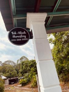 大山脚Tok Abah Homestay Bukit Mertajam的房屋边有柱子的标志