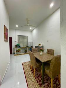 大山脚Tok Abah Homestay Bukit Mertajam的客厅配有木桌和椅子
