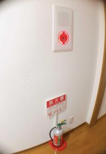 大阪HOSTEL198 Private Room of Second floorーVacation STAY68024v的墙上有红色钟的白色墙壁的房间