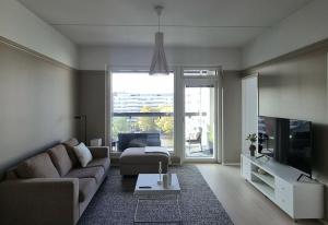 坦佩雷Hotellitasoinen, uusi huoneisto!的带沙发和电视的客厅