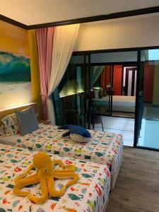 卡塔海滩Must Sea Hotel - SHA Hotel的卧室里设有一张床,上面有一只动物